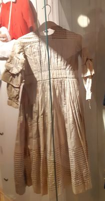 "BarneklÃ¸r fÃ¸r 1970" Tekstilnemdas utstilling pÃ¥ Gulburet 2019.
Her ei barnekjole fra 1860

